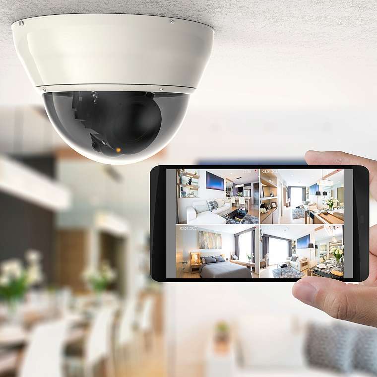 Eine Dome-Kamera an der Decke überwacht einen Raum und sendet die Bilder an ein Handy um auf die Videoüberwachung im Datenschutz hinzuweisen